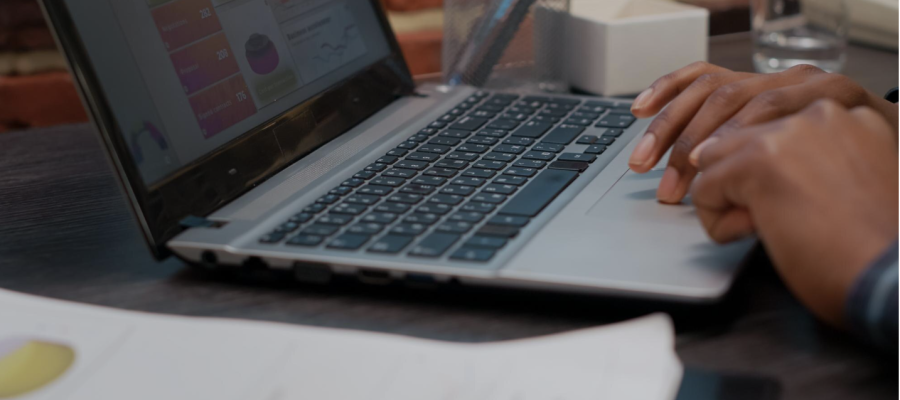 Photo shows close-up of hands typing on laptop